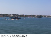Морской тральщик "Железняков" и "Турбинист" проходят вдоль строя военных кораблей на параде в День ВМФ в Севастопольской бухте, Крым (2019 год). Редакционное фото, фотограф Николай Мухорин / Фотобанк Лори
