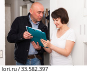 Collector is trying to get the arrears from woman at home door. Стоковое фото, фотограф Яков Филимонов / Фотобанк Лори