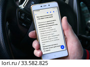 Водитель показывает смартфон с полученным цифровым пропуском для передвижения по городу в период пандемии коронавируса COVID-19 в России. Стоковое фото, фотограф Щеголева Ольга / Фотобанк Лори
