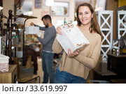 Smiling gir in search of things for home interior. Стоковое фото, фотограф Яков Филимонов / Фотобанк Лори