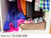 На полке в детском шкафу небрежно валяются детские вещи. Стоковое фото, фотограф Иванов Алексей / Фотобанк Лори