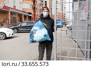 Man taking out garbage during coronavirus pandemic, it is allowed without any permission. Стоковое фото, фотограф Кекяляйнен Андрей / Фотобанк Лори