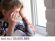 Обиженная девочка горько плачет у окна. Стоковое фото, фотограф Иванов Алексей / Фотобанк Лори