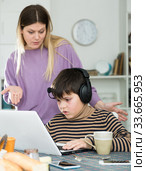 Upset mother arguing with son who plaing video games. Стоковое фото, фотограф Яков Филимонов / Фотобанк Лори