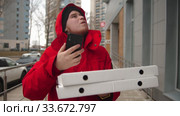 A man courier delivering pizza - walking on the street and looking at the phone. Стоковое видео, видеограф Константин Шишкин / Фотобанк Лори