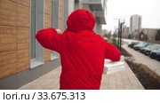 A man courier in red clothes delivering pizza - looking at the watch and running to the door. Стоковое видео, видеограф Константин Шишкин / Фотобанк Лори