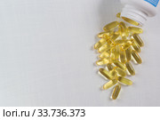 Прозрачные желатиновые овальные капсулы с рыбьим жиром лежат на белом столе. Омега-3 полиненасыщенные жирные кислоты. Место для текста. Стоковое фото, фотограф Наталья Гармашева / Фотобанк Лори
