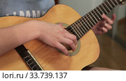 Teenager girl slams on her acoustic guitar, unrecognizable person (2020 год). Редакционное видео, видеограф Кекяляйнен Андрей / Фотобанк Лори