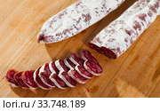 Slicing delicious Spanish smoked sausage fuete. Стоковое фото, фотограф Яков Филимонов / Фотобанк Лори