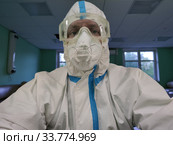 Медбрат работает в защитном костюме в обсервации во время распространения коронавируса (2020 год). Редакционное фото, фотограф Мария / Фотобанк Лори
