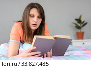 Девушка увлечена чтением книги и переживает за героев. Стоковое фото, фотограф Иванов Алексей / Фотобанк Лори