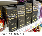 Bottled alcoholic beverages Hennessy cognac on the shelf in supermarket (2019 год). Редакционное фото, фотограф FotograFF / Фотобанк Лори