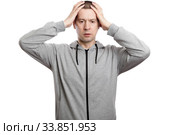disillusioned, distressed man clutched his head in surprise. Dressed in sportswear. Isolated. Стоковое фото, фотограф Владимир Арсентьев / Фотобанк Лори
