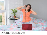 Девушка надела наушники, подключила их к компьютеру и весело слушает музыку. Стоковое фото, фотограф Иванов Алексей / Фотобанк Лори