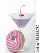 A glass of martini and a pink and white striped donut close-up. photo for the screensaver. In a glass of milkshake milkshake. One cherry on top. Стоковое фото, фотограф Evgeny Miller / Фотобанк Лори