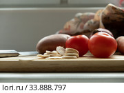 Vegetables on a cutting board. Close-up of tomato, potato and chopped mushrooms. And in the background is a knife. Стоковое фото, фотограф Evgeny Miller / Фотобанк Лори