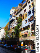 Hundertwasser house in Vienna, Austria. The Hundertwasserhaus apartment block has colorful facade, undulating floors, a roof covered with earth and grass, and large trees growing from inside (2019 год). Редакционное фото, фотограф Nataliia Zhekova / Фотобанк Лори