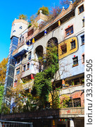 Hundertwasser house in Vienna, Austria. The Hundertwasserhaus apartment block has colorful facade, undulating floors, a roof covered with earth and grass, and large trees growing from inside (2019 год). Стоковое фото, фотограф Nataliia Zhekova / Фотобанк Лори