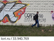Москва, мужчина в маске на фоне рисунков граффитистов (2020 год). Редакционное фото, фотограф Дмитрий Неумоин / Фотобанк Лори