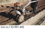 Closeup of hand plough tilling soil on field before seeding. Spring agricultural work. Стоковое видео, видеограф Яков Филимонов / Фотобанк Лори