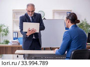 Yound and old employees in business presentation concept. Стоковое фото, фотограф Elnur / Фотобанк Лори