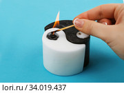 White and black Yin Yang handmade candle on blue background. Стоковое фото, фотограф Nataliia Zhekova / Фотобанк Лори