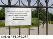 Табличка "Соблюдайте дистанцию" на ограде парка. Москва (2020 год). Редакционное фото, фотограф Елена Орлова / Фотобанк Лори
