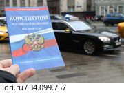 Брошюра конституции Российской Федерации на против дорогой правительственной машины с мигалкой у Государственной Думы (2020 год). Редакционное фото, фотограф Кузнецов Максим / Фотобанк Лори