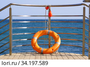 Спасательный круг на причале на фоне моря. Безопасность на воде. Стоковое фото, фотограф ирина реброва / Фотобанк Лори
