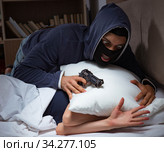 Burglar breaking into house at night to bedroom with sleeping wo. Стоковое фото, фотограф Elnur / Фотобанк Лори