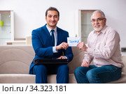 Young male lawyer visiting old man in testament concept. Стоковое фото, фотограф Elnur / Фотобанк Лори