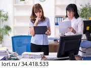 Two female employees and excessive work in the office. Стоковое фото, фотограф Elnur / Фотобанк Лори