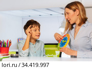 Woman teach boy with autism clock and hours. Стоковое фото, фотограф Сергей Новиков / Фотобанк Лори