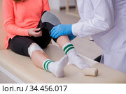 Young leg injured woman visiting old doctor traumatologist. Стоковое фото, фотограф Elnur / Фотобанк Лори