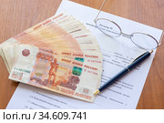 На столе лежит договор купли продажи земельного участка, пачка денег, ручка и очки. Стоковое фото, фотограф Иванов Алексей / Фотобанк Лори
