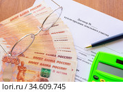 На столе лежит договор купли продажи земельного участка, пачка денег, калькулятор, очки и ручка. Стоковое фото, фотограф Иванов Алексей / Фотобанк Лори