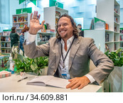 Сергей Полонский улыбается на автограф-сессии после презентации книги "Взламывая стереотипы. Освобожденный" на Московской Международной Книжной ярмарке (2020 год). Редакционное фото, фотограф Сайганов Александр / Фотобанк Лори