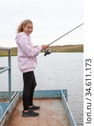 Pre-teen girl portrait with fish rod, female fisherman catching the fishes from pier. Стоковое фото, фотограф Кекяляйнен Андрей / Фотобанк Лори