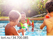 Group of friends play with water gun fight in pool. Стоковое фото, фотограф Сергей Новиков / Фотобанк Лори