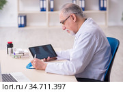 Old male doctor radiologist in telehealth concept. Стоковое фото, фотограф Elnur / Фотобанк Лори