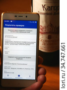Результаты проверки алкогольной продукции на экране сотового телефона после сканирования акцизной марки. Использование специального мобильного приложения (2020 год). Редакционное фото, фотограф Щеголева Ольга / Фотобанк Лори
