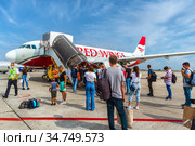 Посадка пассажиров в самолет «Аэробус» А320 авиакомпании Red Wings («Ред Вингс») в Международном аэропорту Краснодар имени Екатерины II (Пашковский) (2020 год). Редакционное фото, фотограф Владимир Сергеев / Фотобанк Лори