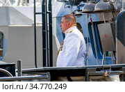 Офицер (капитан 1-го ранга) на борту противодиверсионного катера П-104 «Нахимовец» (бортовой № 689). Военные корабли на параде в День ВМФ.Санкт-Петербург (2020 год). Редакционное фото, фотограф Сергей Афанасьев / Фотобанк Лори