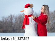 Девушка в красном пальто и снеговик. Стоковое фото, фотограф 1Andrey Милкин / Фотобанк Лори
