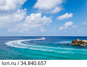 Tourist boat rounding a rocky cape with a lighthouse in the Maldives (2017 год). Стоковое фото, фотограф Сергей Фролов / Фотобанк Лори