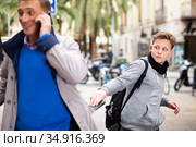 Teenager thieving wallet from man pocket. Стоковое фото, фотограф Яков Филимонов / Фотобанк Лори