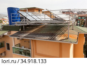 Solar glass water panel array mounted on a roof for heating. Huge tank for hot water. Heater with green energy for a hotel needs. Alanya, Turkey. Стоковое фото, фотограф Кекяляйнен Андрей / Фотобанк Лори