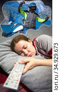 Young Caucasian woman sleeping on couch with daydreams about travel by motorcycle. TV remote control is in hand. Стоковое фото, фотограф Кекяляйнен Андрей / Фотобанк Лори