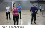 Smiling dancing people practicing bachata movements in dance studio for adults. Стоковое видео, видеограф Яков Филимонов / Фотобанк Лори