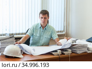 Man engineer qualified in structural design working on the detailed project report in office. Стоковое фото, фотограф Кекяляйнен Андрей / Фотобанк Лори